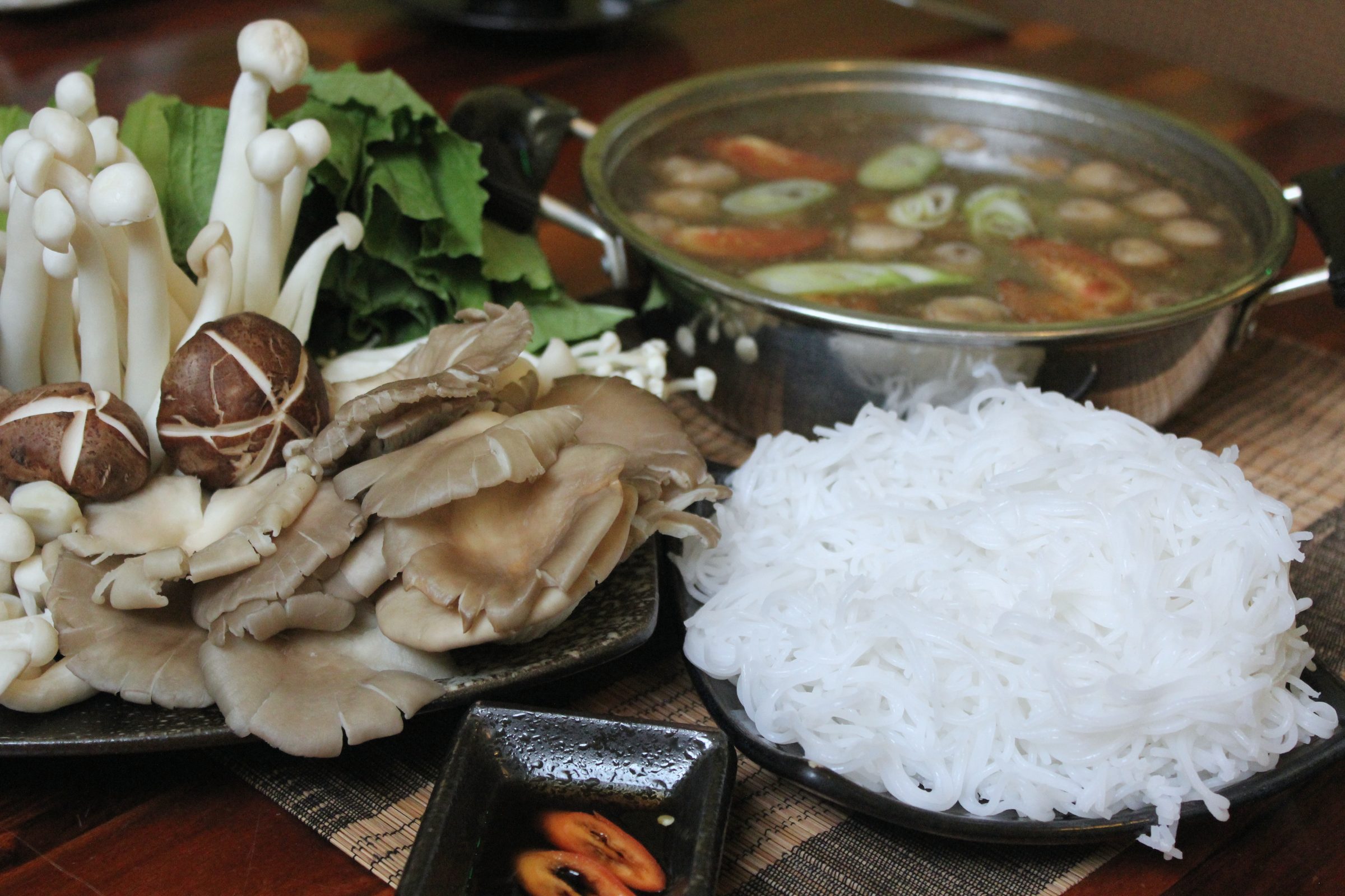 Lẩu nấm với mẹt nấm tươi, rau và bún