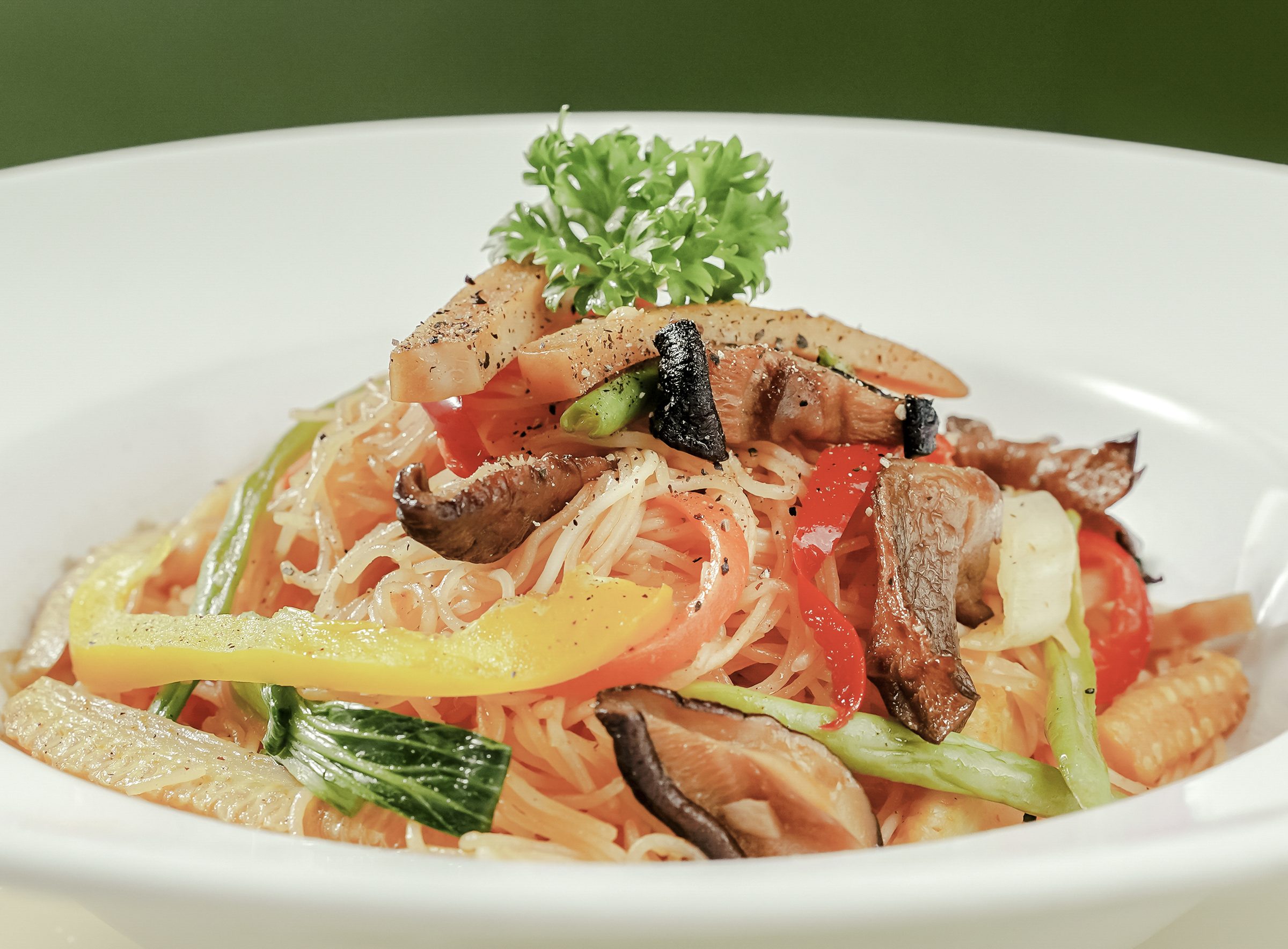 Hủ tiếu xào rau củ nấm trên dĩa trắng
