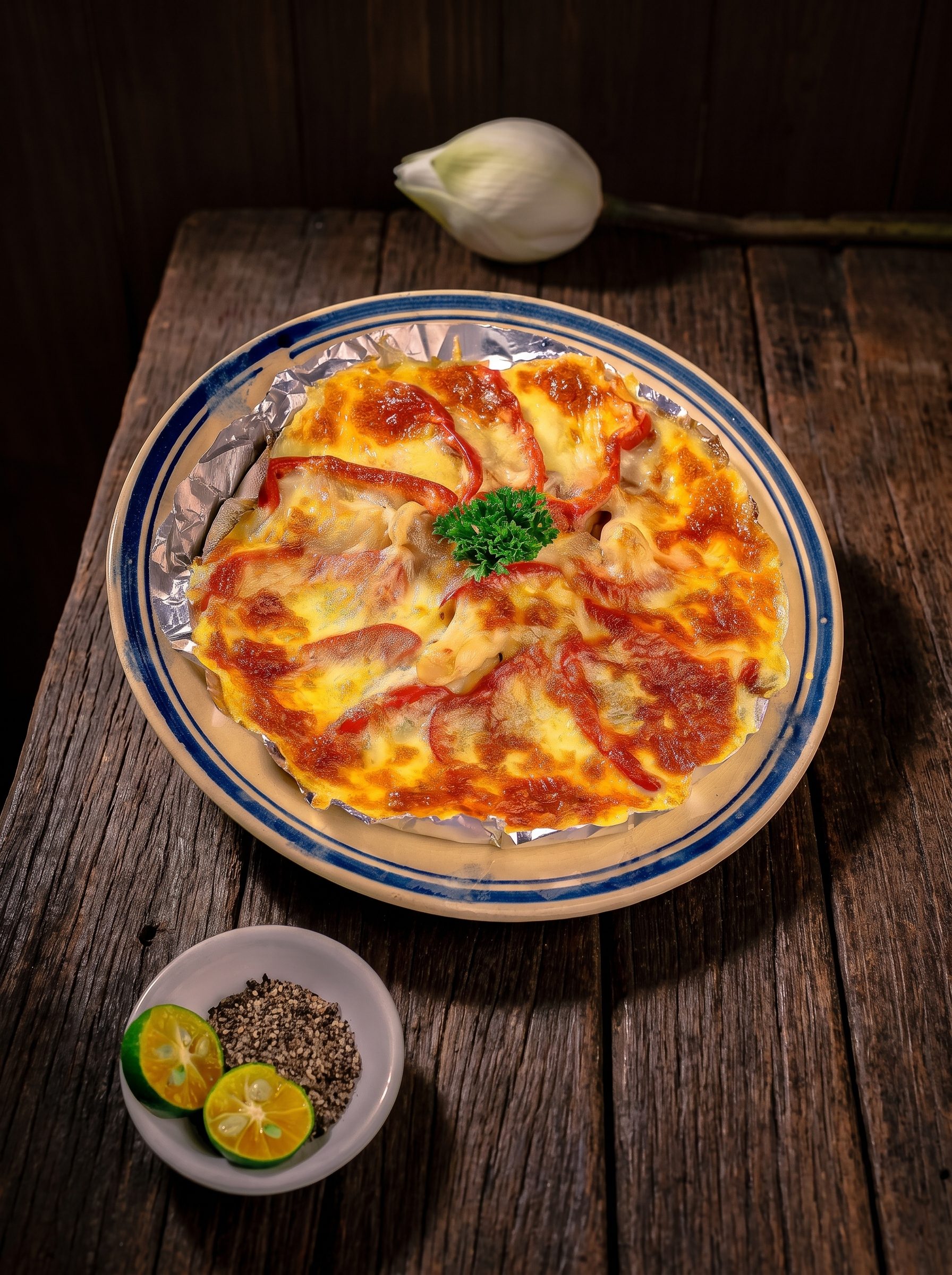 Pizza chay trên dĩa men viền xanh bên búp sen trắng